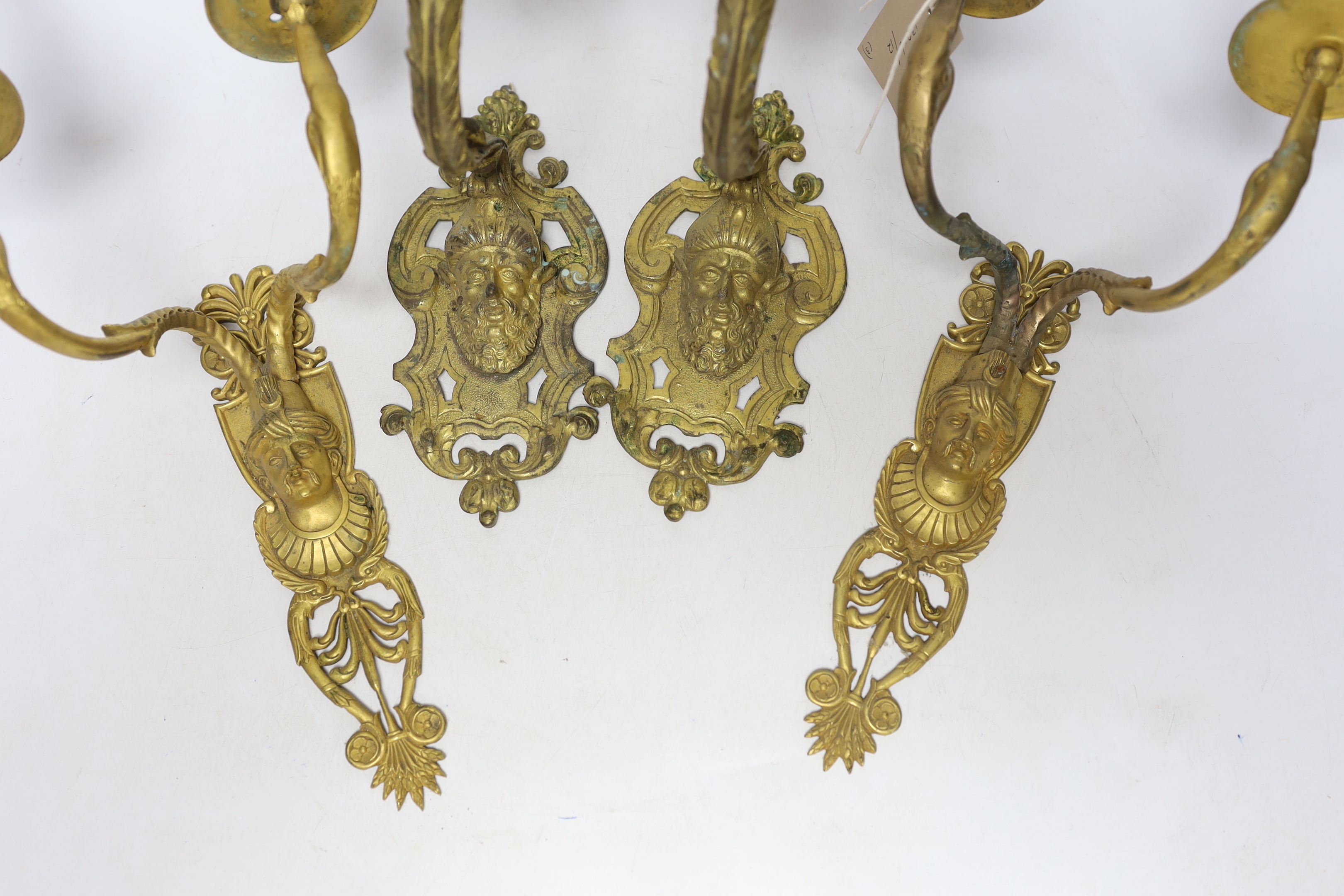 A pair of ormolu two branch wall lights, a pair of single branch mask wall lights and a small pair of wall lights, largest 32cm high